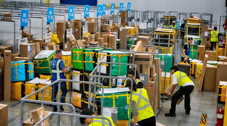FILE - Amazon employees load packages on carts before being put on to trucks for distribution for Amazon's annual Prime Day event at an Amazon's DAX7 delivery station on July 16, 2024, in South Gate, Calif. (AP Photo/Richard Vogel, File)