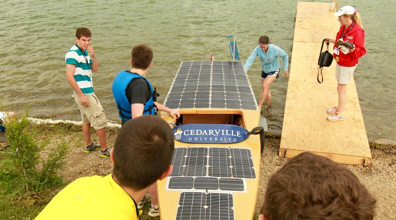 Cedarville University Solar Splash team members made up of senior engineering students lower their solar powered boat into the water for the qualifying competition during a recent event at Eastwood Park Lake. Cedarville is the most decorated participant in Solar Splash history, having won the Collegiate World Championship at least seven times. JIM WITMER / STAFF
