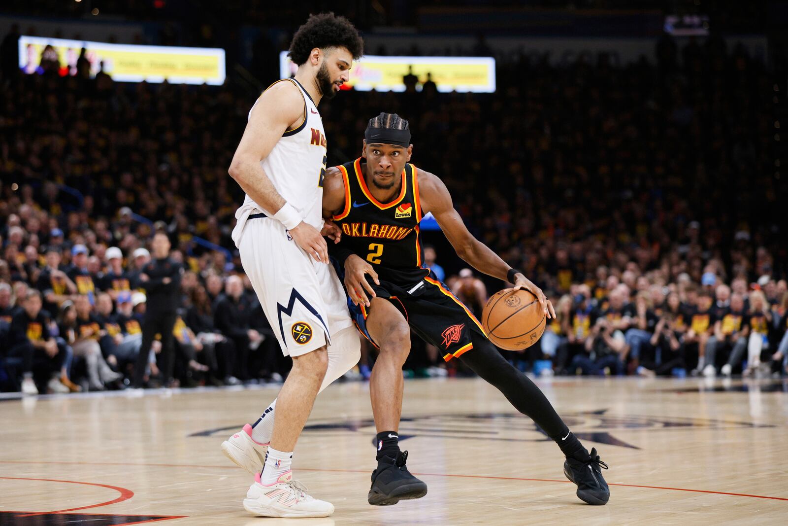 Oklahoma City Thunder's Shai Gilgeous-Alexander (2) works for a shot attempt as Denver Nuggets' Jamal Murray, left, defends in the second half of Game 1 of an NBA basketball second-round playoff series Monday, May 5, 2025, in Oklahoma City. (AP Photo/Nate Billings)