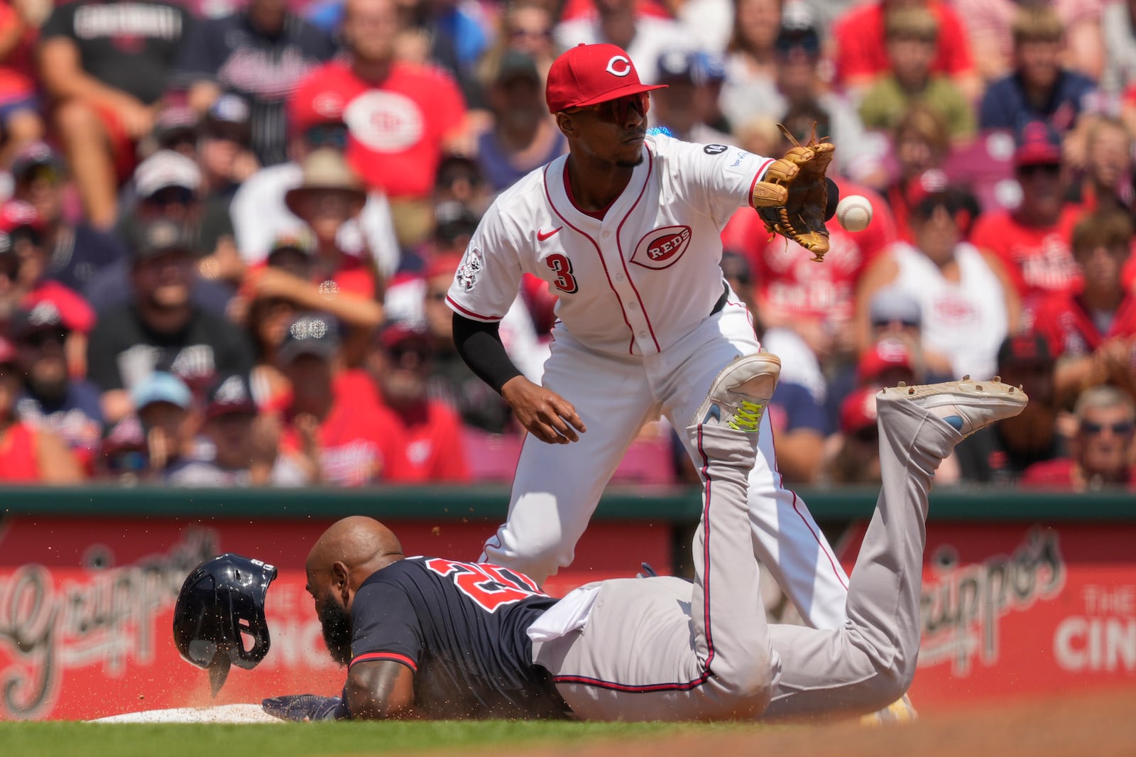 Cincinnati Reds third baseman Ke'Bryan Hayes takes the throw as Atlanta Braves Marcell Ozuna is safe at third base during the ninth inning of a baseball game, Friday, Aug. 1, 2025, in Cincinnati. (AP Photo/Carolyn Kaster)