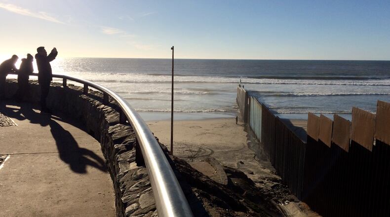 People look out towards where border structure separates San Diego, right, from Tijuana, Mexico, left, Wednesday, Jan. 25, 2017. President Donald Trump moved aggressively to tighten the nation's immigration controls Wednesday, signing executive actions to jumpstart construction of his promised U.S.-Mexico border wall and cut federal grants for immigrant-protecting "sanctuary cities." (AP Photo/Julie Watson)
