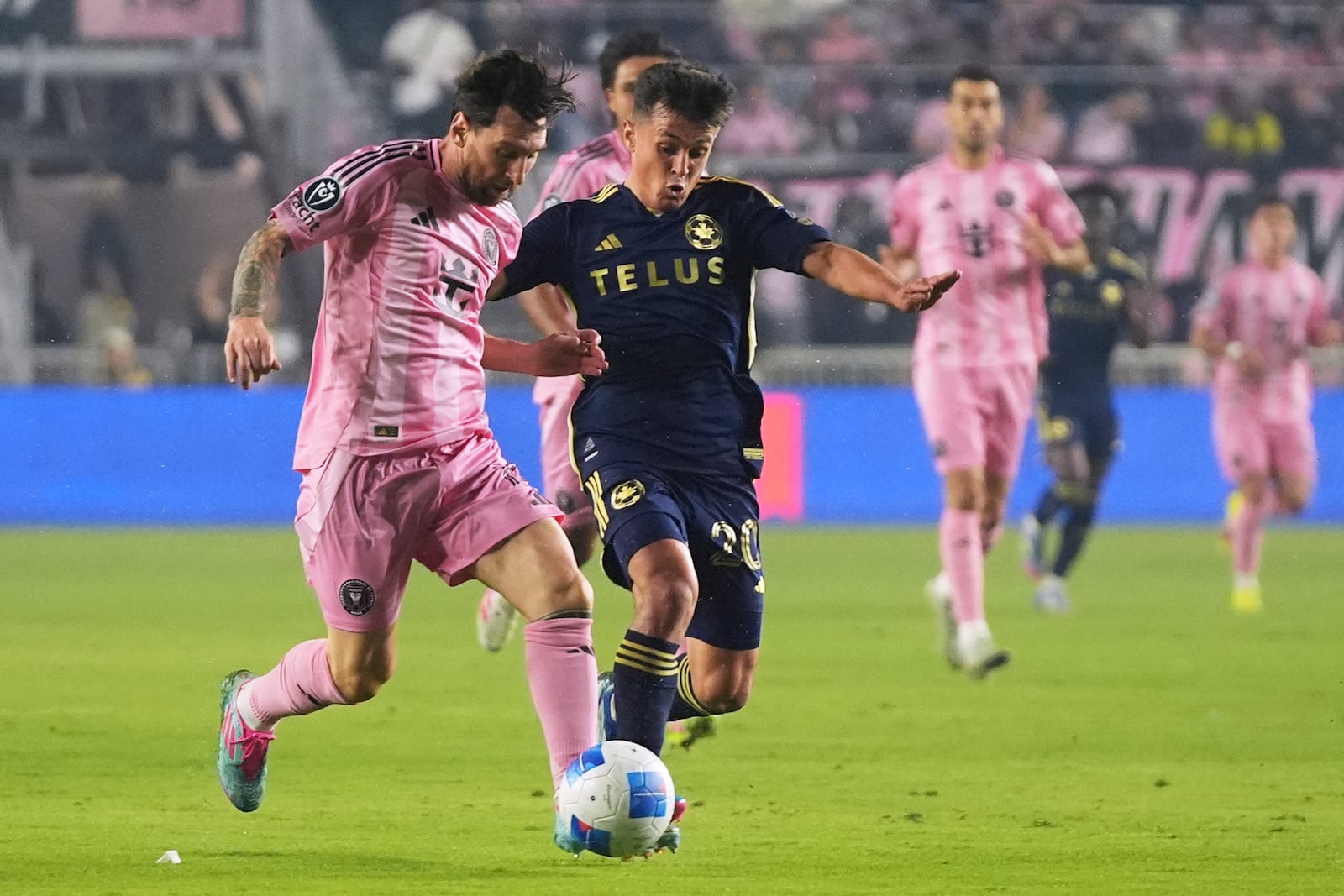 Inter Miami forward Lionel Messi, left, runs for the ball against Vancouver Whitecaps midfielder Andrés Cubas, right, during the first half of a CONCACAF Champions Cup second-leg semifinal soccer match, Wednesday, April 30, 2025, in Fort Lauderdale, Fla. (AP Photo/Lynne Sladky)
