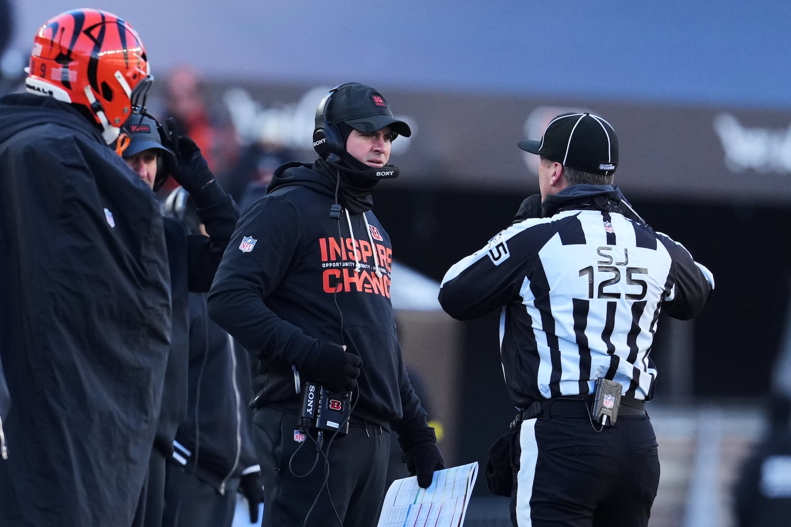 Cincinnati Bengals head coach Zac Taylor, left, talks with side judge Chad Hill (125) during the second half of an NFL football game against the Baltimore Ravens, Sunday, Dec. 14, 2025, in Cincinnati. (AP Photo/Jeff Dean)
