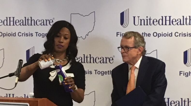 Dr. Corinn Taylor, left, demonstrates an opioid disposal kit as Ohio Attorney General Mike DeWine watches during an event Thursday, June 7 at Kettering Medical Center in Kettering. WILL GARBE / STAFF