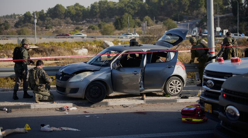 Members of Israeli security forces inspect the site of a ramming and stabbing attack near the West Bank Jewish settlement of Gush Etzion, Tuesday, Nov. 18, 2025. (AP Photo/Ohad Zwigenberg)