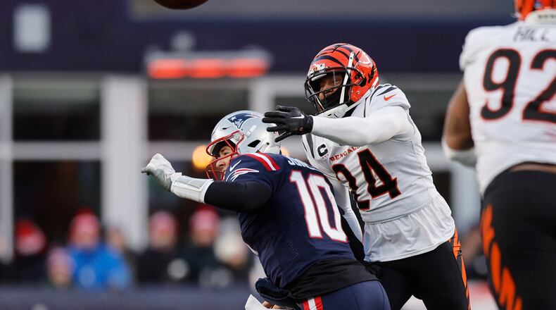 New England Patriots quarterback Mac Jones (10) loses control of the ball under pressure from Cincinnati Bengals safety Vonn Bell (24) during the second half of an NFL football game, Saturday, Dec. 24, 2022, in Foxborough, Mass. (AP Photo/Michael Dwyer)
