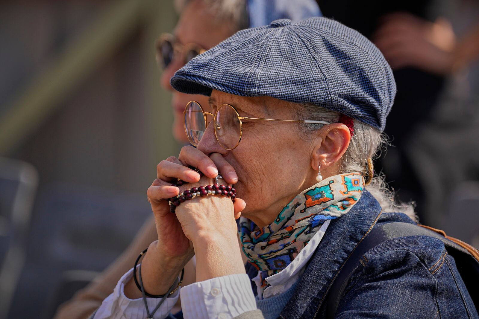 A woman prays in St. Peter's Square as people wait to pay their respects to the late Pope Francis, who will lie in state at St. Peter's Basilica for three days, at the Vatican, Wednesday, April 23, 2025. (AP Photo/Andreea Alexandru)