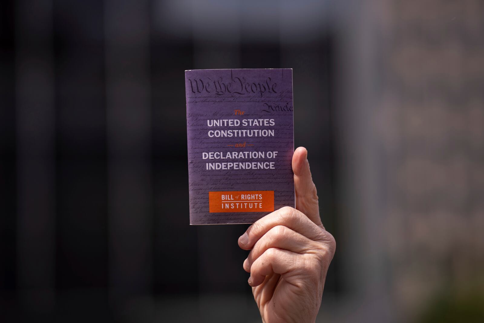 A person holds a copy of the Constitution of the United States of America and Declaration of Independence at a May Day rally for the Rule of Law, Thursday, May 1, 2025, in New York. (AP Photo/Adam Gray)