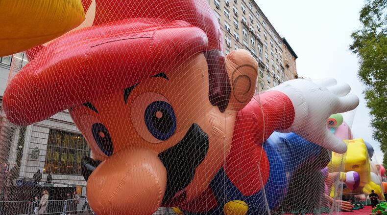People pass Mario balloon during inflation for the 99th Macy's Thanksgiving Day Parade Wednesday, Nov. 26, 2025, in New York. (AP Photo/Frank Franklin II)