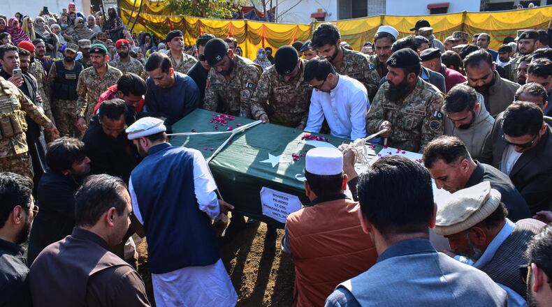 Relatives and army soldiers carry the casket of an army officer, who was killed in the suicide bombing in the border district of Bannu, for his burial following a funeral prayer in Mansehra, Pakistan, Sunday, Feb. 22, 2026. (AP Photo/Saqib Manzoor)