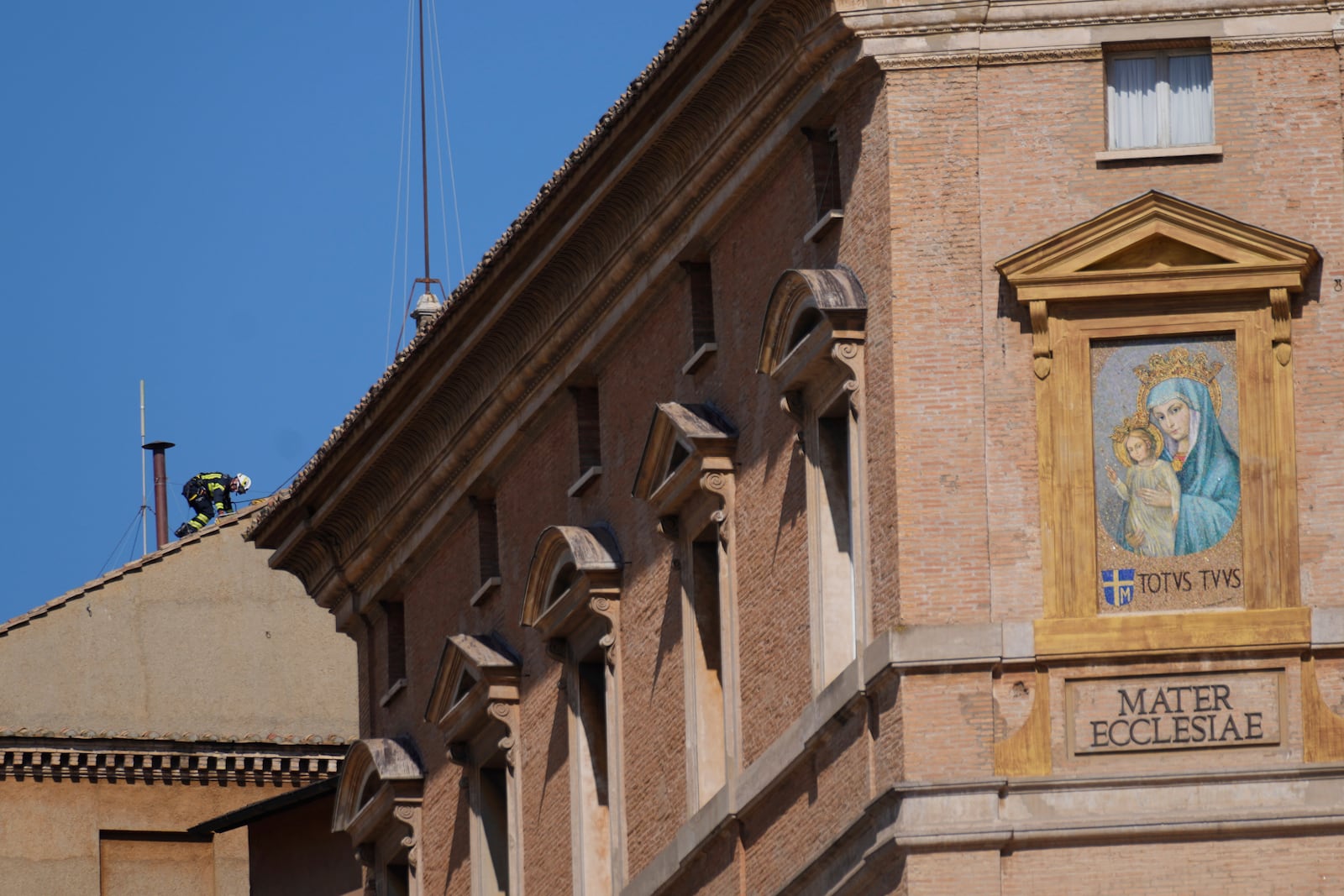 Firefighters place the chimney on the roof of the Sistine Chapel, where cardinals will gather to elect the new pope, at the Vatican, Friday, May 2, 2025. (AP Photo/Gregorio Borgia)