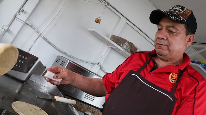 Cabrera-Caudillo Apolinar flips tortillas in his food truck in New Carlisle Wednesday. New Carlisle changes its rules for food trucks, allowing them to stay open year round. Bill Lackey/Staff