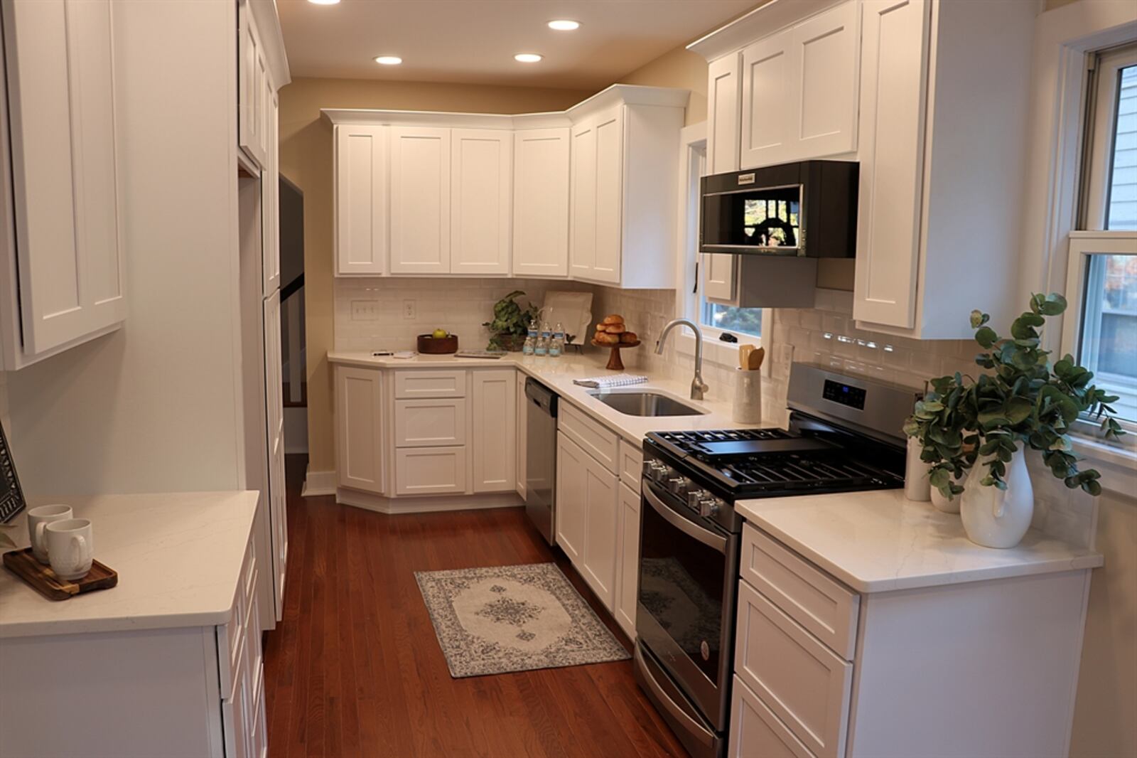 Accessible from the living room and the front foyer, the galley kitchen has quartz counters on white cabinetry that fills both walls and wraps around stainless-steel appliances. Contributed photo by Kathy Tyler
