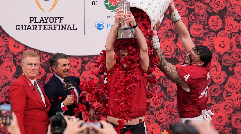 Indiana head coach Curt Cignetti holds the winner's trophy as he is doused with rose pedals by linebacker Aiden Fisher (4) after a win over Alabama in the Rose Bowl College Football Playoff quarterfinal game Thursday, Jan. 1, 2026, in Pasadena, Calif. (AP Photo/Mark J. Terrill)