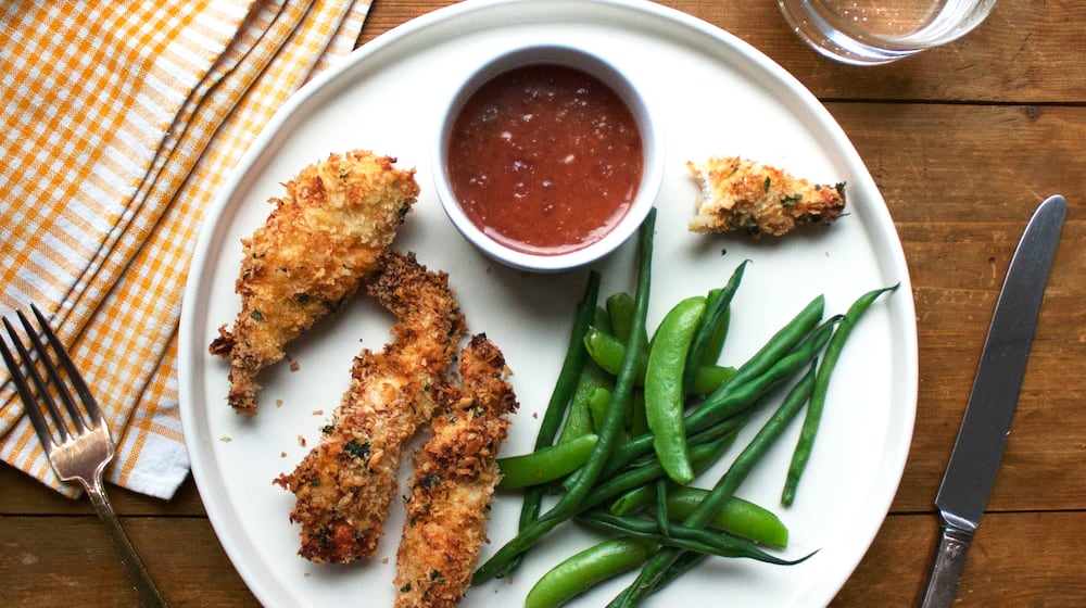 This image shows a recipe for crispy chicken strips with an apricot mustard dipping sauce. (Katie Workman via AP)
