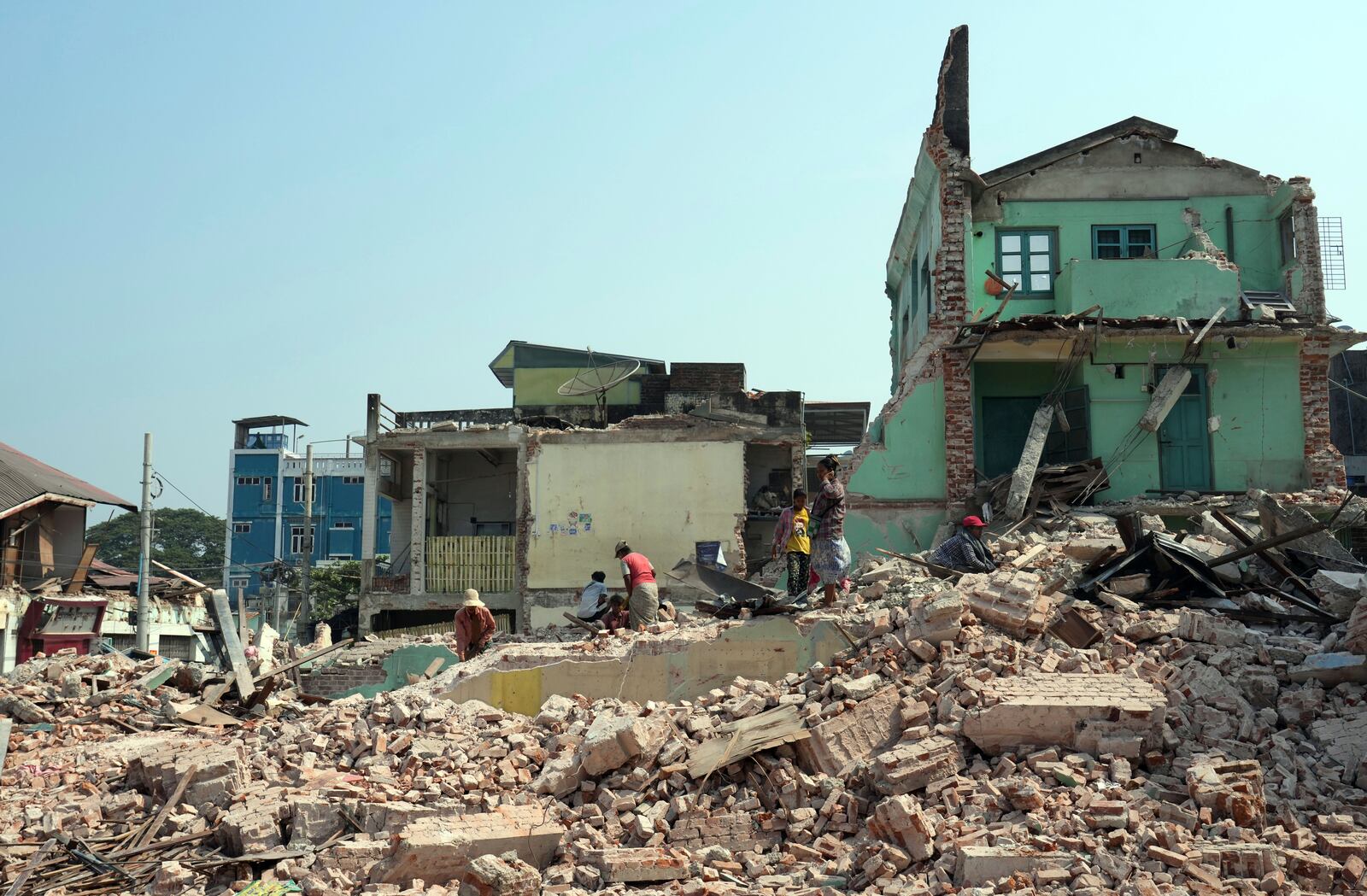 Volunteers help to clear collapsed buildings after one month of the strong earthquake in Naypyitaw, Myanmar, Monday, April 28, 2025. (AP Photo/Aung Shine Oo)