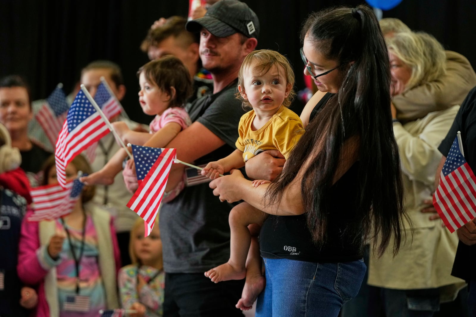 Afrikaner refugees from South Africa holding American flags arrive, Monday, May 12, 2025, at Dulles International Airport in Dulles, Va. (AP Photo/Julia Demaree Nikhinson)