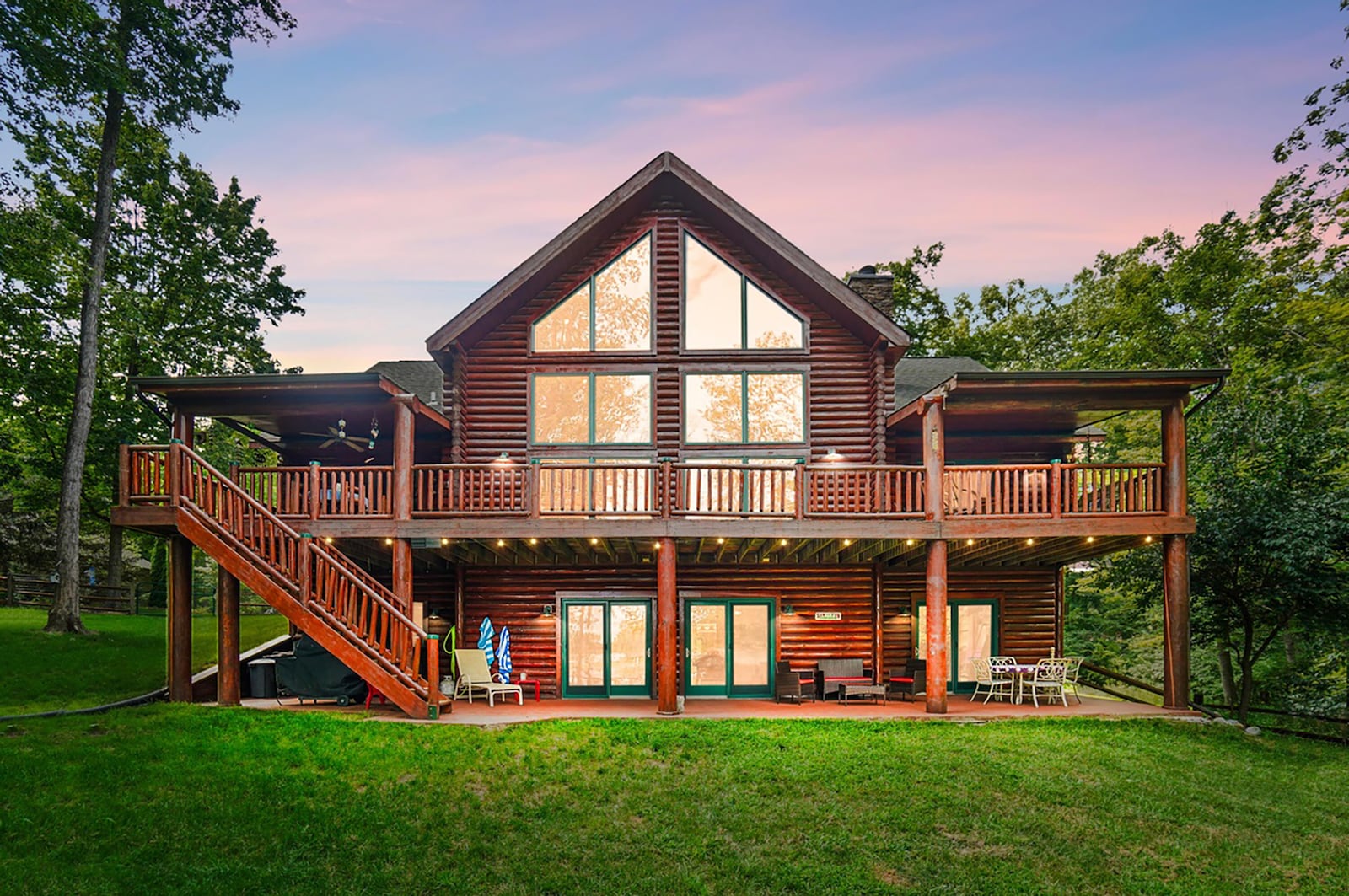 The rear of this custom log home has wrap around deck with railings and steps leading down to the walk out basement and patio. It has a private dock on Lake Sylvan. CONTRIBUTED