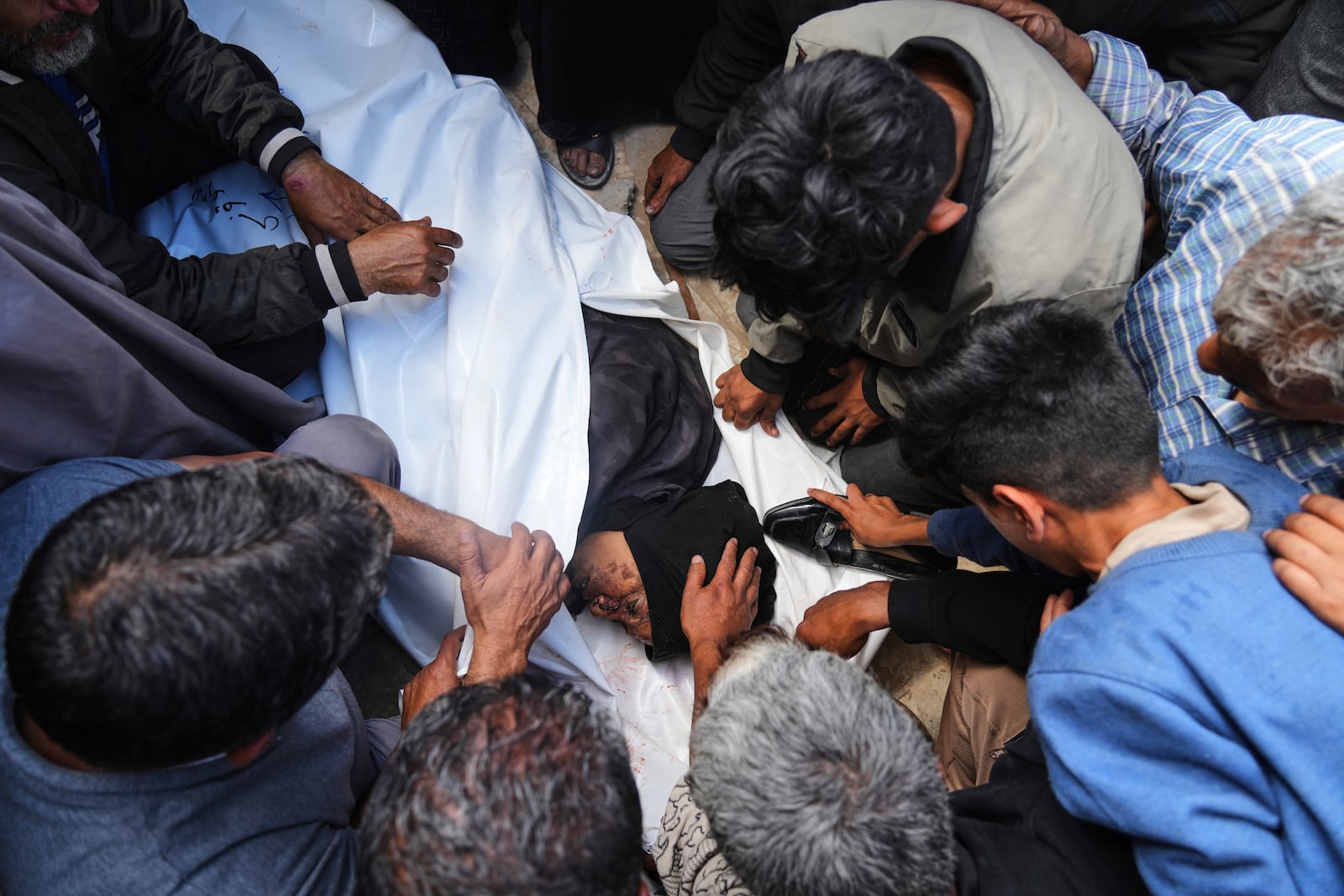 Palestinians mourn over the body of Reem Al-Akhras who was killed while heading to a Gaza aid hub, during her funeral at the Nasser Hospital in Khan Younis, southern Gaza Strip, Tuesday, June 3, 2025. (AP Photo/Abdel Kareem Hana)