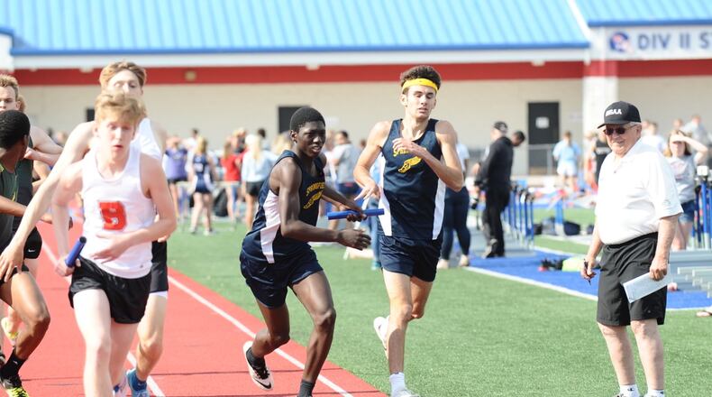 Springfield’s Vincent Fisher (left) receives the baton from Drew Heims during the boys 3,200-meter relay at the Division I district meet Wednesday at Piqua High School. Greg Billing / Contributed