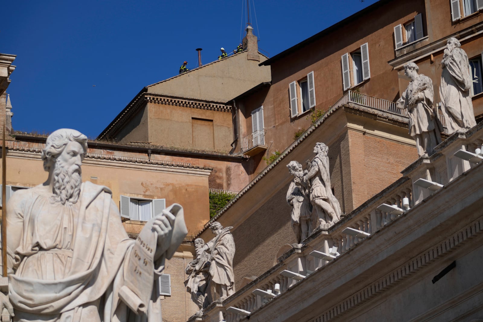 Firefighters place the chimney on the roof of the Sistine Chapel, where cardinals will gather to elect the new pope, at the Vatican, Friday, May 2, 2025. (AP Photo/Gregorio Borgia)