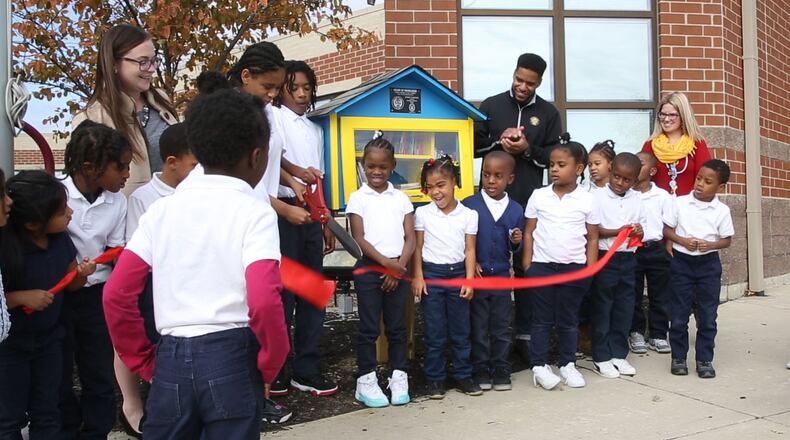 Dayton Public School Fairview PreK-6 School students participated in a ribbon cutting for a new House of Knowledge book exchange library. The small library cabinet was built by Boy Scout Troup 68 Cody Granger as an Eagle Scout project. TY GREENLEES / STAFF