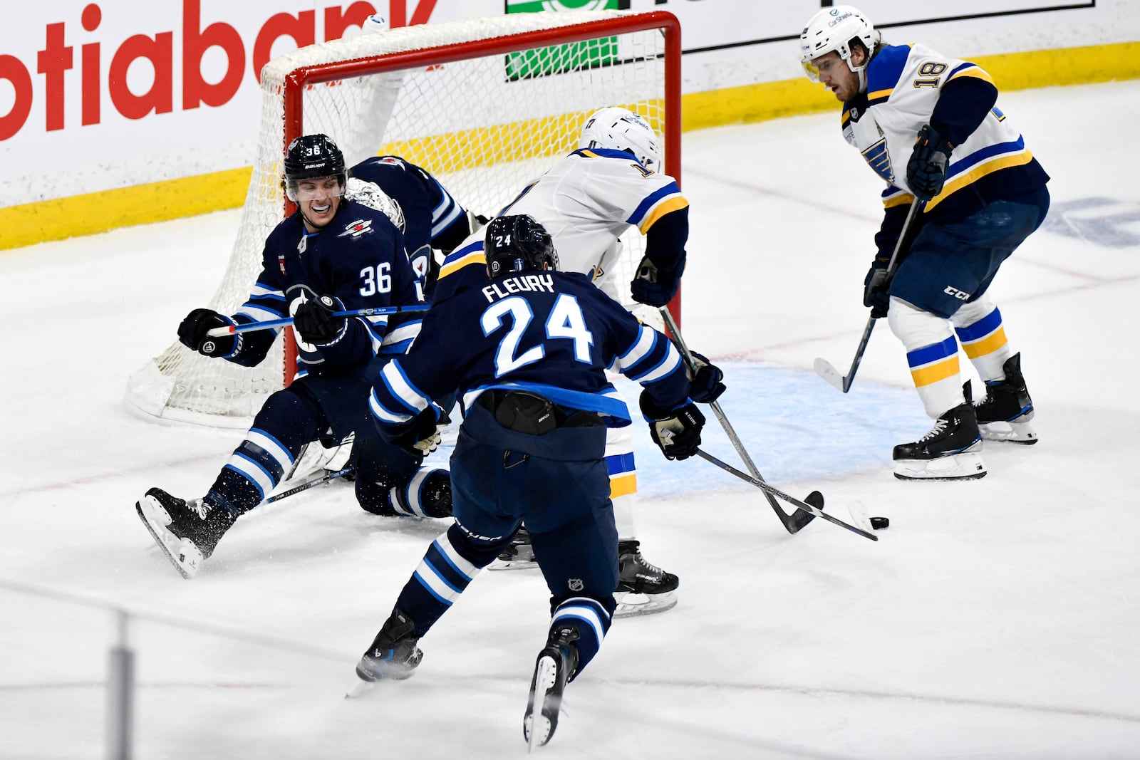 Winnipeg Jets' Morgan Barron (36) and Haydn Fleury (24) defend against St. Louis Blues' Cam Fowler (17) and Robert Thomas (18) in front of Jets goaltender Connor Hellebuyck, second from left, during the second period of Game 7 in an NHL hockey first-round playoff series in Winnipeg, Manitoba, Sunday, May 4, 2025. (Fred Greenslade/The Canadian Press via AP)
