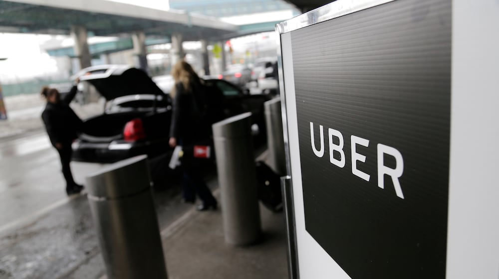 FILE - In this March 15, 2017, file photo, a sign marks a pickup point for the Uber car service at LaGuardia Airport in New York. (AP Photo/Seth Wenig, File)