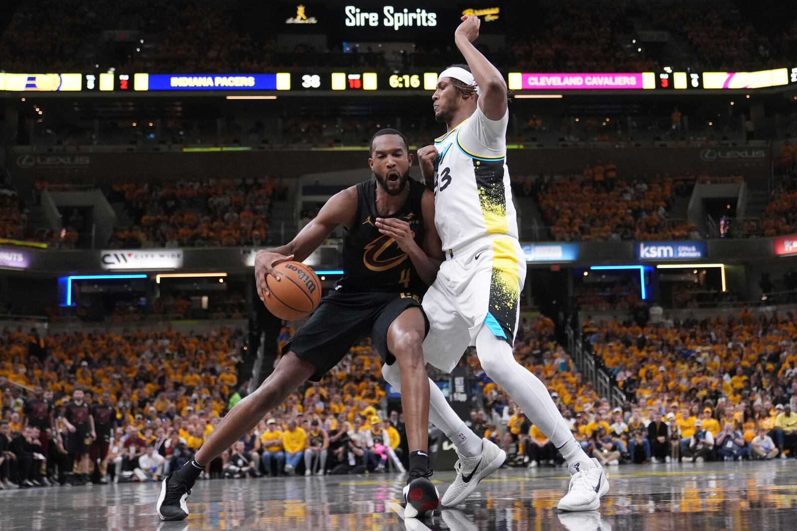 Cleveland Cavaliers center Evan Mobley (4) dribbles the ball against Indiana Pacers center Myles Turner (33) during the first half of Game 3 in the Eastern Conference semifinals of the NBA basketball playoffs in Indianapolis, Friday, May 9, 2025. (AP Photo/Michael Conroy)