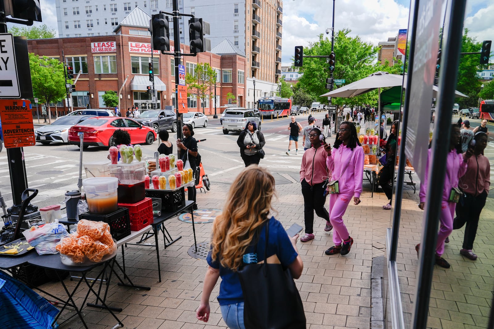 People walk past fruit vendors, Tuesday, May 6, 2025, in the Columbia Heights neighborhood of Washington. (AP Photo/Julia Demaree Nikhinson)