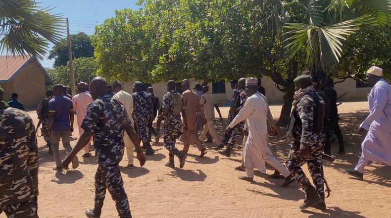 Police and government officials walk past St. Mary's Catholic Primary and Secondary School where gunmen on Friday abducted children and staff in Papiri community, Nigeria, Tuesday, Nov.25, 2025. (AP Photo/Yunusa Umar )