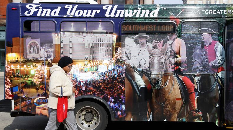 Lynn Perkins walks past the pictures on a SCAT bus at the transportation hub in downtown Springfield Monday, Nov. 6, 2023. BILL LACKEY/STAFF