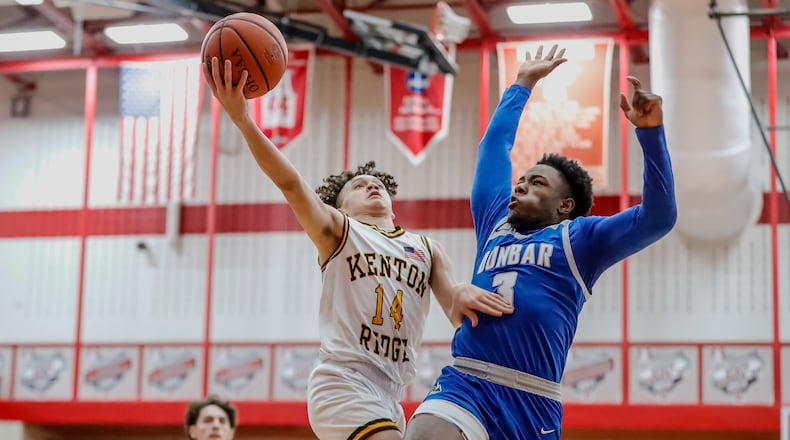 Kenton Ridge High School sophomore Xavier White drives to the hoop against Dunbar senior Jimmy Hill during their game on Tuesday night at Trotwood-Madison High School. The Cougars won 45-42. Michael Cooper/CONTRIBUTED