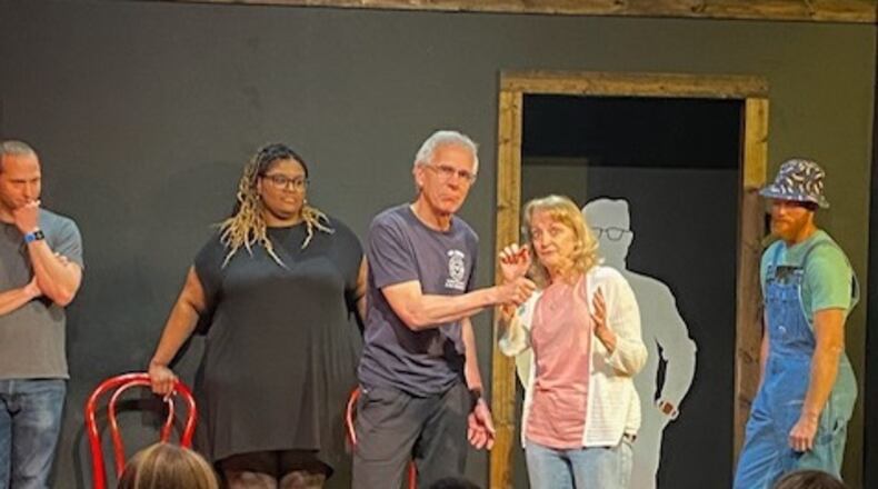 Dean Waggenspack pretends to hold a micophone up to his wife Rose Waggenspack as they take center stage during a Black Box Improv Theater show. CONTRIBUTED