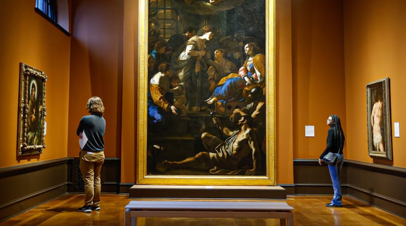 Two patrons study the oil on canvas by Mattia Preti titled, The Roman Empress Faustina visiting Saint Catherine of Alexandria in Prison at the Dayton Art Institute. JIM NOELKER/STAFF
