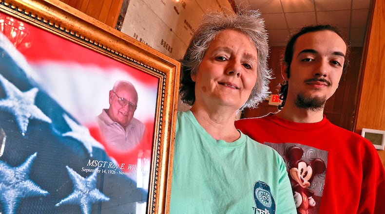 Connie Wilson and her son, Mikey Ziegler, hold a picture of Connie's father, Roy, at Rose Hill Cemetary, where he's buried. BILL LACKEY/STAFF