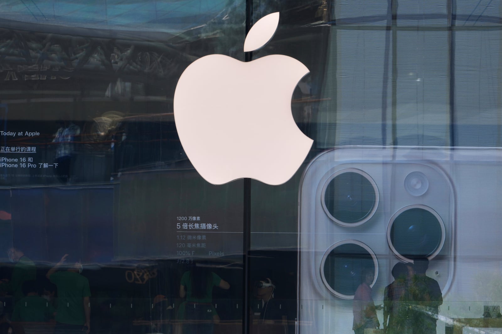 People visit an Apple store promoting its iPhone 16 at an outdoor shopping mall in Beijing, Sunday, May 11, 2025. (AP Photo/Andy Wong)