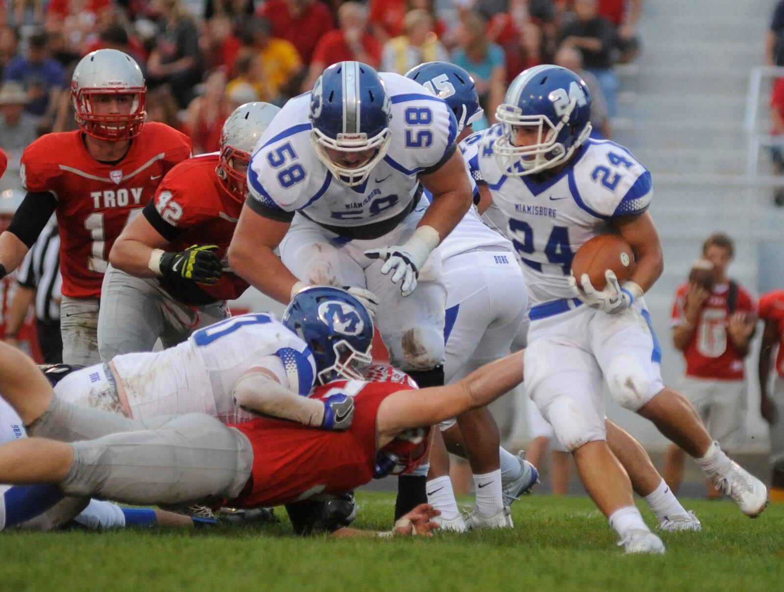 OSU recruit Josh Myers (58) overcame an early ankle injury and helps pave the way for running back Tony Clark. Miamisburg defeated Troy 21-17 in a Week 5 high school football GWOC crossover game at Troy’s Memorial Stadium on Friday, Sept. 23, 2016. MARC PENDLETON / STAFF
