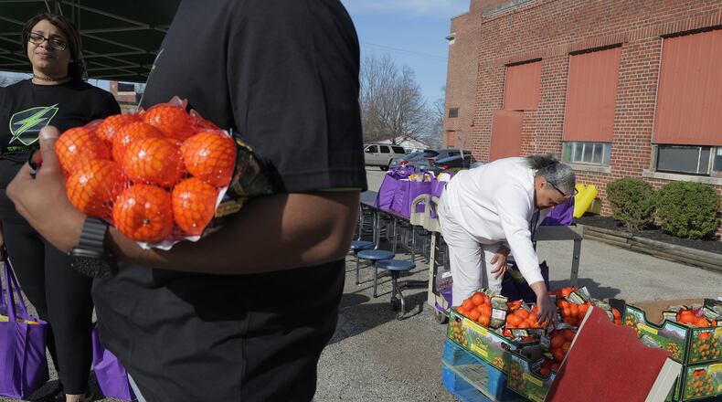The teachers and staff at Springfield Sports Academy wait for a car during their first drive-thru food pantry Tuesday, March 18, 2025 to help fight hunger in the Springfield community. BILL LACKEY/STAFF