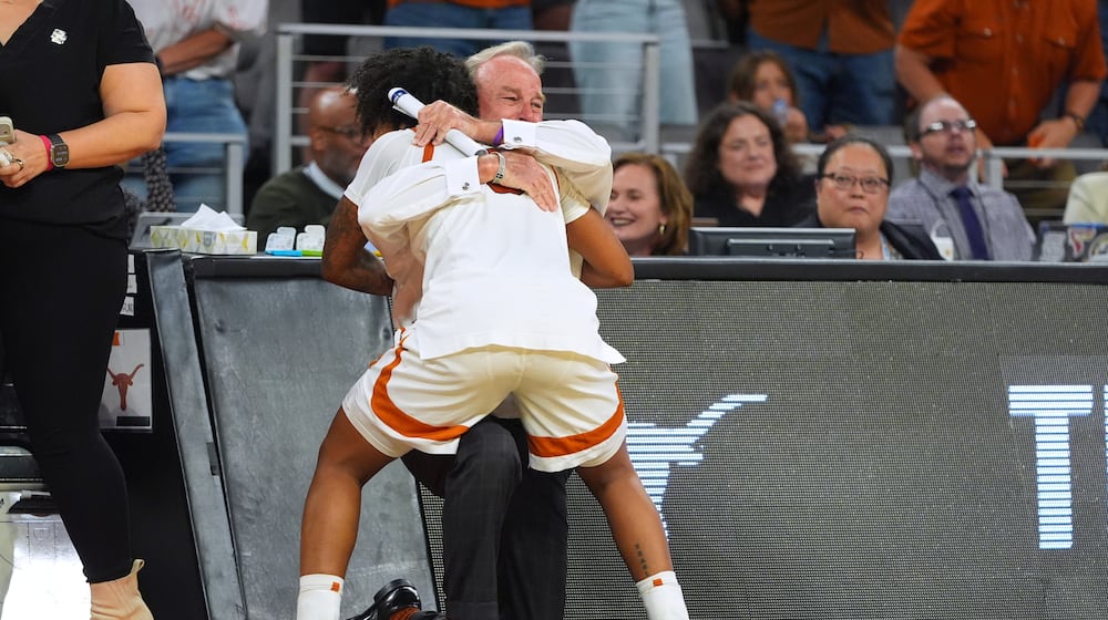 Texas guard Rori Harmon (3) hugs head coach Vic Schaefer against Michigan during the second half in the Elite Eight of the NCAA college basketball tournament, Monday, March 30, 2026, in Fort Worth, Texas. (AP Photo/LM Otero)