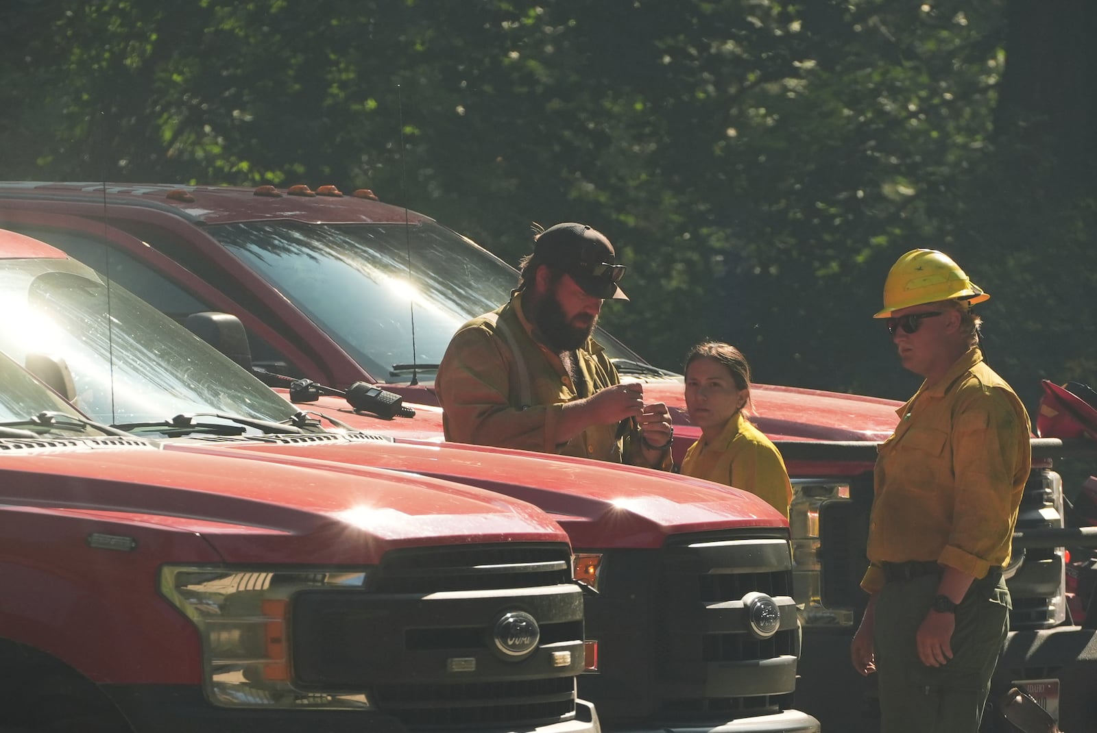 Idaho Department of Lands firefighters stand near a roadblock close to the scene the day after a shooter ambushed and killed multiple firefighters responding to a wildfire at Canfield Mountain Monday, June 30, 2025, in Coeur D'Alene, Idaho. (AP Photo/Lindsey Wasson)