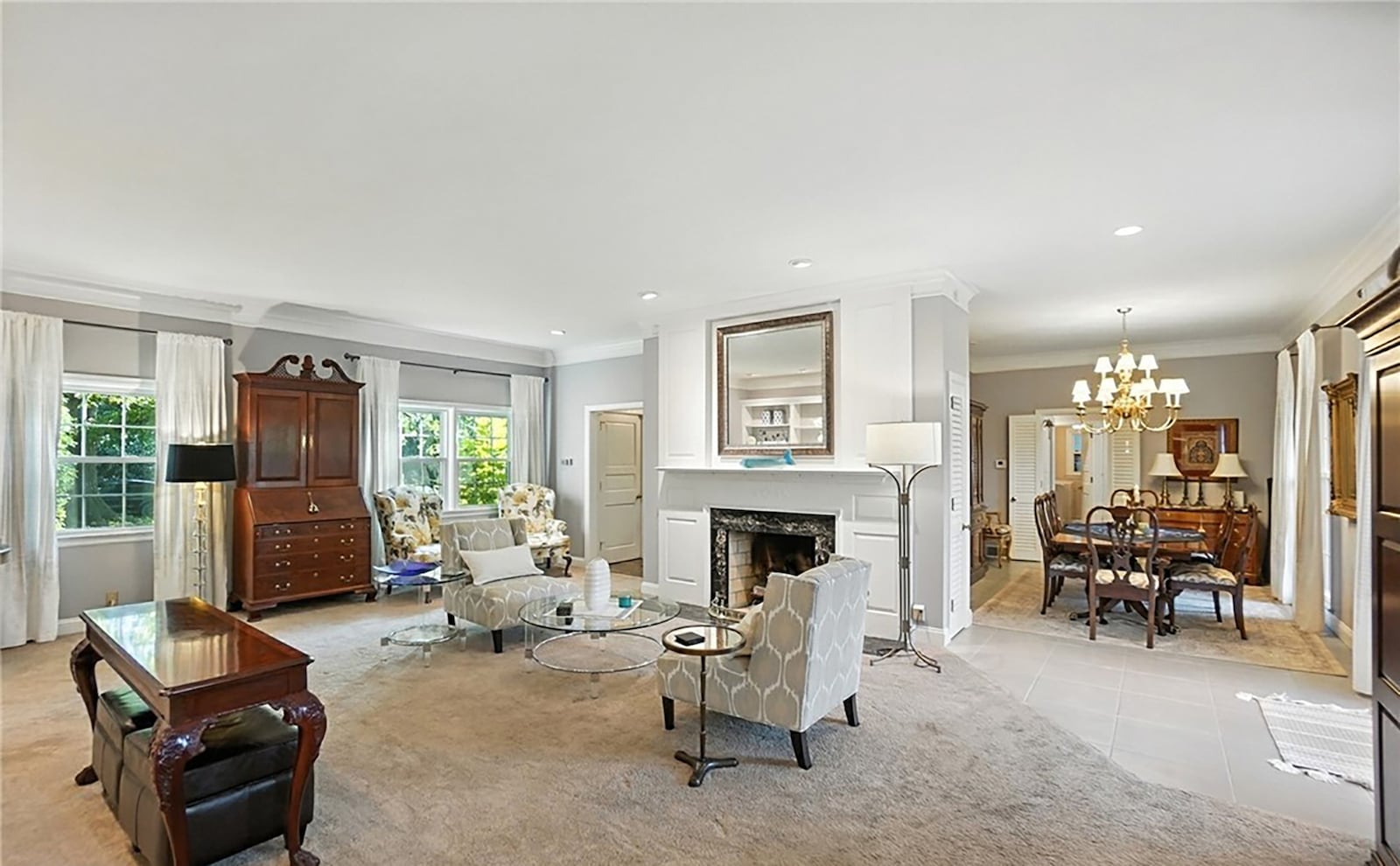 The living room has neutral carpeting and a gas fireplace as well as a wall of built in bookcases. CONTRIBUTED