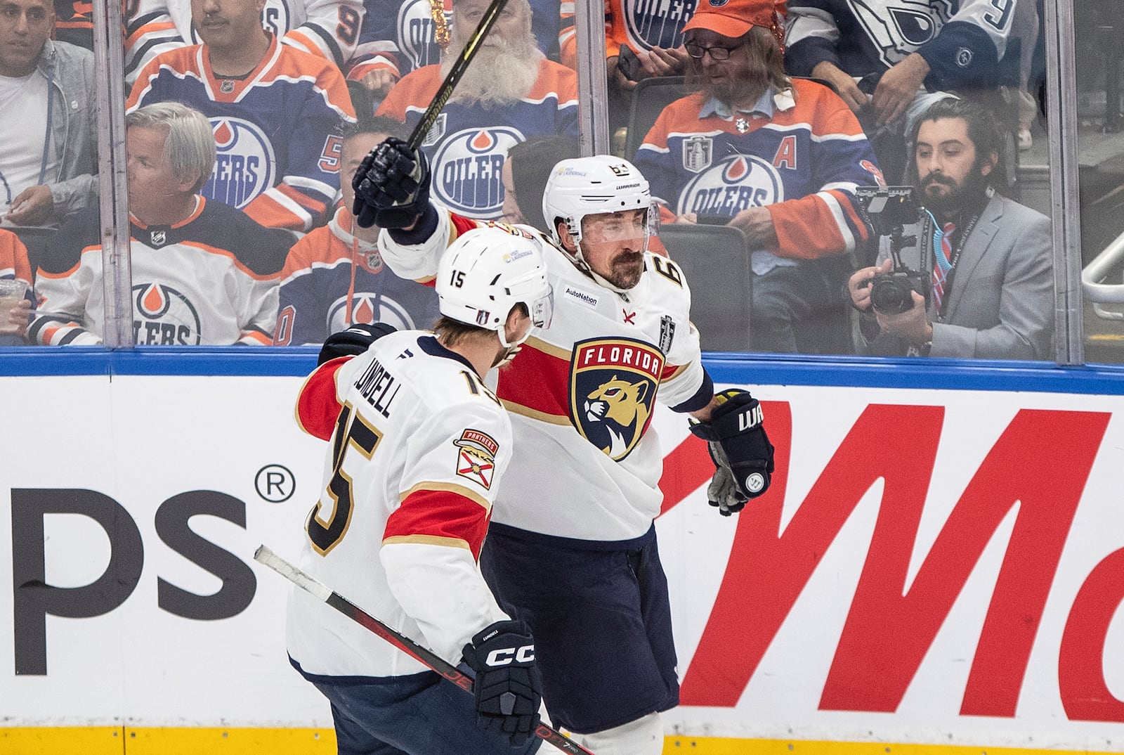 Florida Panthers' Anton Lundell (15) and Brad Marchand (63) celebrate after a goal against the Edmonton Oilers during the third period in Game 5 of the NHL hockey Stanley Cup Final in Edmonton, Alberta, Saturday, June 14, 2025. ( Jason Franson/The Canadian Press via AP)
