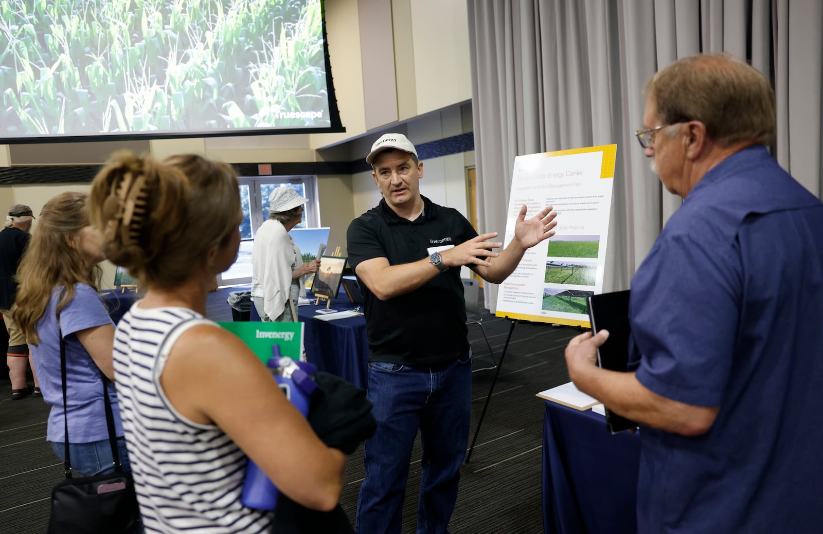 Ben Balskus, center, senior associate of vegetation management at Invenergy, talks to Heather Chapel, left, and her dad, Sam George, during a public information meeting held by Invenergy on Tuesday, July 8, 2025, at Hollenebeck Center to get feedback on the 180-megawatt Sloopy Solar Energy Center. JOSEPH COOKE/STAFF