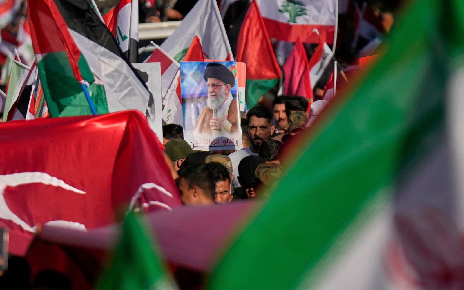 A protest holds a portrait of Iran's Supreme Leader Ayatollah Ali Khamenei during a rally to show solidarity with Iran in the Shi'ite district of Kazimiyah, in Baghdad, Iraq, Saturday, June 21, 2025. (AP Photo/Hadi Mizban)