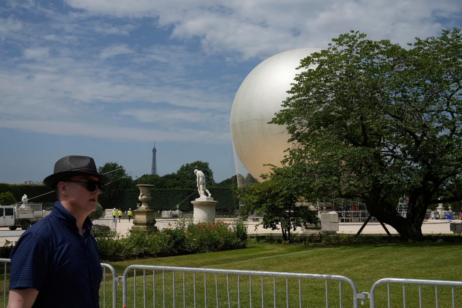 A man walks past the Olympic cauldron at the Tuileries Gardens, ahead of its nightly summer relaunch starting June 21, in Paris, Thursday, June 12, 2025. (AP Photo/Michel Euler)