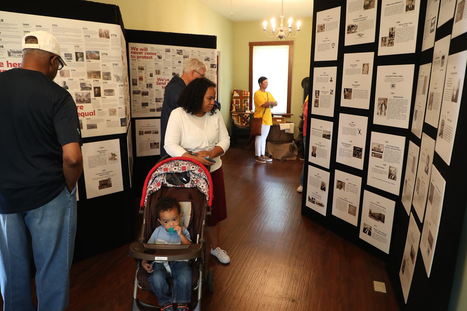 Guests look over all the information about slavery and the Underground Railroad as they tour the Gammon House during the 2019 Juneteenth Celebration and FatherFest. BILL LACKEY/STAFF