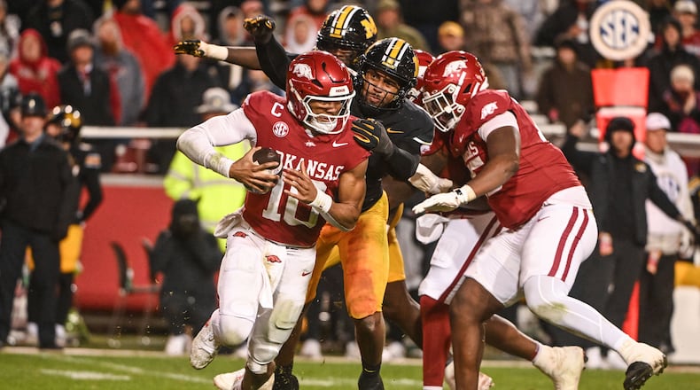 Arkansas quarterback Taylen Green (10) is sacked by Missouri defensive end Damon Wilson II, center, during the second half of an NCAA college football game Saturday, Nov. 29, 2025, in Fayetteville, Ark. (AP Photo/Michael Woods)