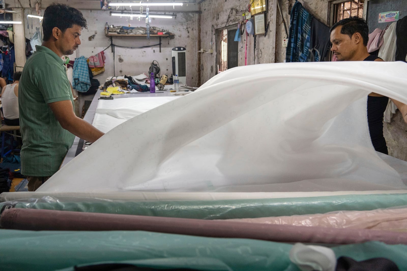 FILE - Workers sort clothes at a factory located in a slum in Dharavi, Mumbai, India, Thursday, April 10, 2025. (AP Photo/Rafiq Maqbool, File)