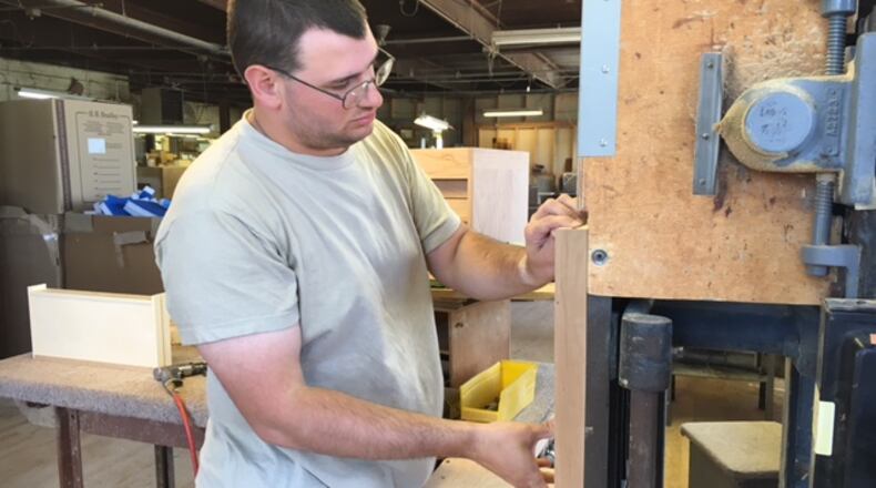 Worker Sean Maguire sands a wooden chest drawer for final fitting recently at Gerstner & Sons in Dayton. THOMAS GNAU/STAFF